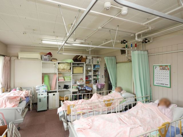 居室の明るい様子 メディカルルーム ゆとりのあるスペースの居室で、利用者さまは安心してお過ごしいただけます。暖かみのあるカーテンがプライバシーを保ちつつ、柔らかな光を取り入れています。