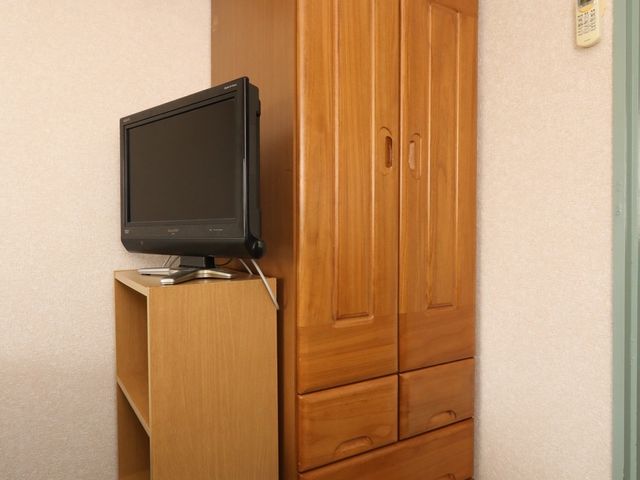 木製のタンスとテレビ 居室 整えられた居室の一角です。必要なものがすぐ手に取れるよう配慮されており、快適な日常生活を送れる空間となっています。