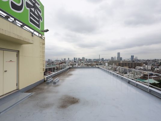 障害物のない開放的な屋上で、周りは転落防止用のフェンスで囲まれている。ビルやマンションなどが立ち並ぶ、都会の街並みが見渡せる。