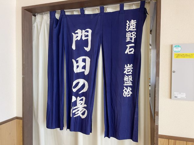 青いのれんのエントランス 浴室 心温まる出迎えを予感させる、落ち着いた雰囲気のエントランスです。青いのれんが印象的で、安心感を与えてくれます。