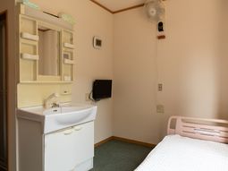 居室の洗面台とベッド