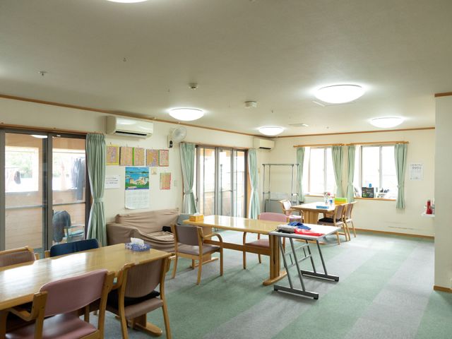共有スペースの居室 共有スペース 広々とした居室には、明るく柔らかな光が差し込み、椅子やテーブルが配された居心地の良い環境です。利用者の皆さんが集う場所として、温かな交流の場を提供しています。