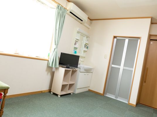 明るい個室のエアコンとテレビ