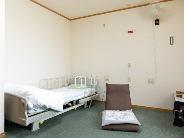 清潔な居室の一角 電動リクライニングベッド 広々とした居室では、個々のスペースが配慮され、静かな環境でゆったりとお過ごしいただけます。