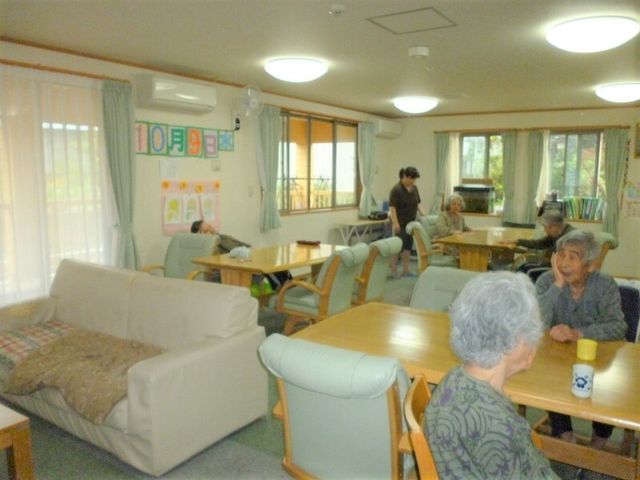 共有スペースの日常風景 リビングダイニング 明るく広々としたラウンジで、利用者同士が心地よい時間を過ごしている様子が伺えます。会話や読書を通じて、豊かな日々を支えています。