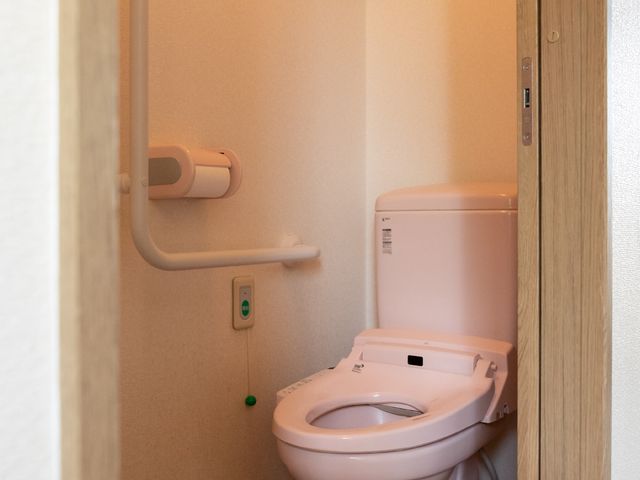 バリアフリートイレ トイレ 手すり付きの清潔感のあふれるトイレです。どなたでも使いやすい設計になっており、安心してご利用いただけます。