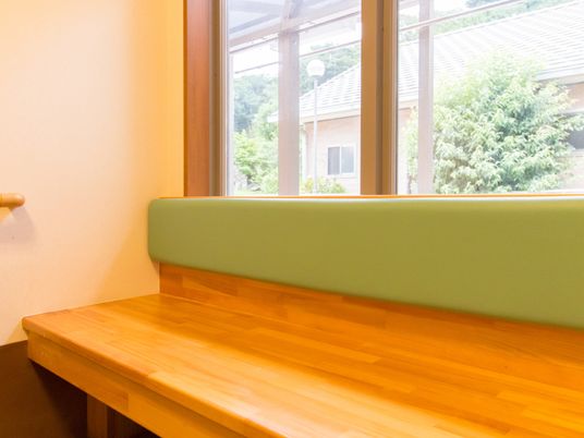 窓際のベンチと木目調テーブル