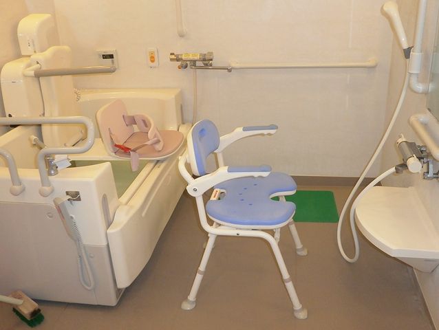 介助用浴槽と椅子の浴室 浴室   手すりやシャワーチェアが備わった浴室です。入浴時の介助に配慮したつくりが見られます。