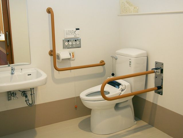 手すり付きトイレ トイレ   手すりが複数設置されたトイレです。手洗い器も近くにあり、動作のしやすさに配慮されています。