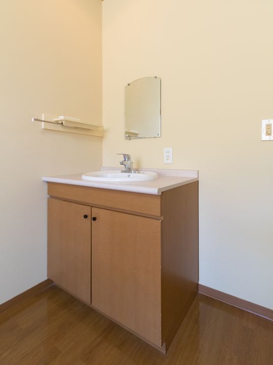 広々とした居室には洗面台があり、シンクにはレバー式混合栓を備え付けている。また壁には鏡が取り付けられている。