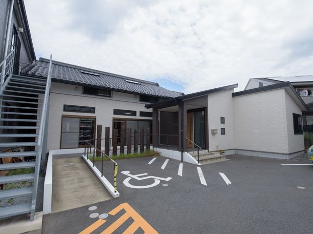 車椅子マークのあるエントランス 外観 広々とした車椅子対応エントランスです。バリアフリー設計でどなたでもスムーズにお入りいただけます。