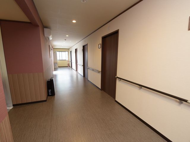 広々とした明るい廊下 廊下 ゆったりとした空間が広がる通路は、移動がしやすい設計になっております。手すりが整っていて安心感を与える環境です。