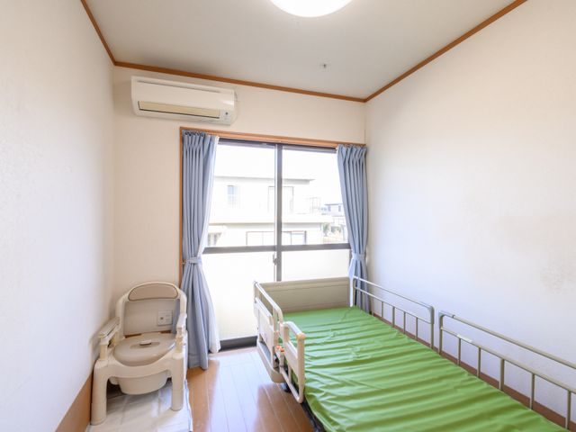 居室の清潔な空間 居室 日当たりの良い広々とした居室は、機能的なベッドと手すり付きトイレが配置され、快適な居住環境を提供しています。