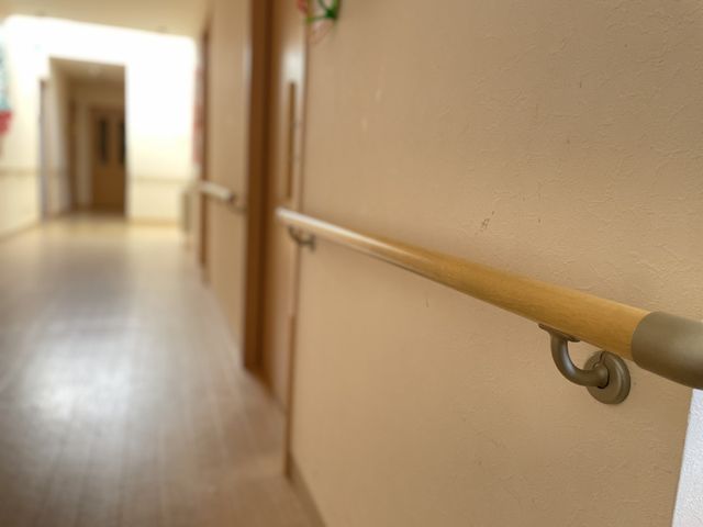 手すり付きの廊下 廊下 手すりが設置された温かみのある色合いの廊下です。安全に配慮された設計で、ゆったりと歩けます。