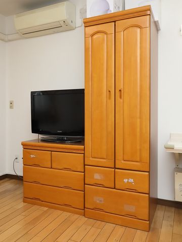 居室のテレビとクローゼット 整理ダンス きれいな床と調和する木製の収納家具が置かれた居室です。個々のスペースを大切にしながら、快適な生活をサポートします。
