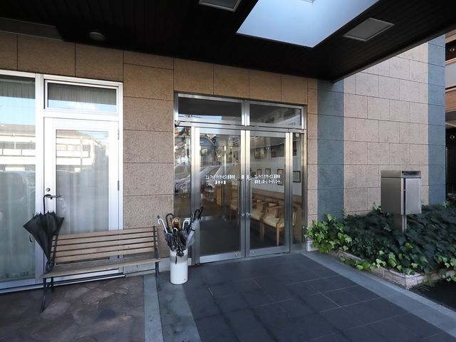 エントランスの自動ドア 入口 明るく開放的なエントランスを備えた施設です。訪問者を温かく迎えるデザインが印象的です。