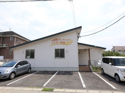 白い壁の建物と駐車場