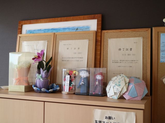 掲示物と装飾の棚 掲示物 あたたかい雰囲気を持つスペースには、心を込めた手作りの装飾が飾られ、訪れる人々に穏やかな印象を与えています。
