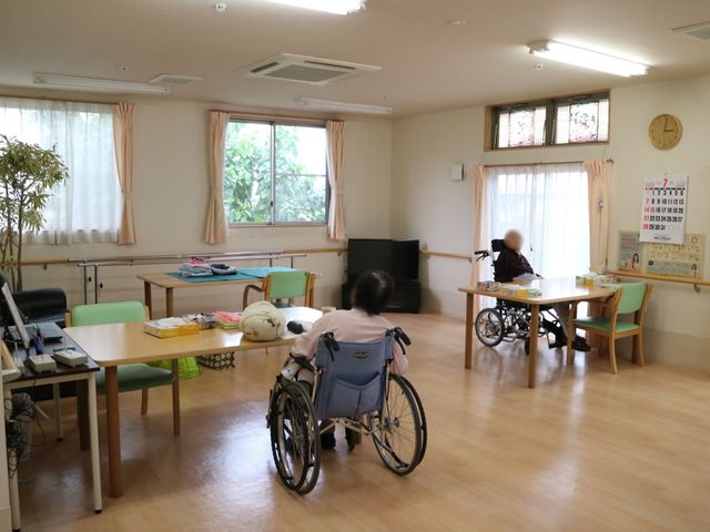 明るい居間の日常風景 共有スペース ゆったりとした居室で、入居者が日々の時間を過ごしています。共有スペースは、交流やリラックスに最適な設計です。