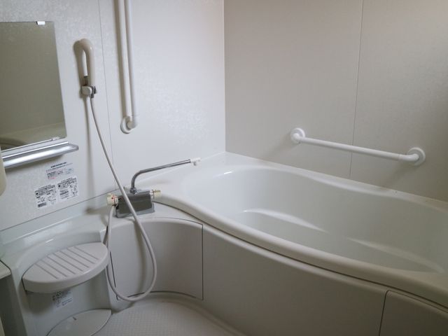 手すり付き浴槽とトイレ 浴室 手すりが設けられた清潔感あふれる浴室で、利用者の安全と快適性が考慮されています。