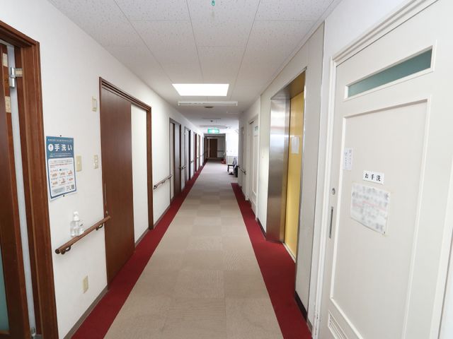 廊下の手すりと掲示物 廊下 清潔感あふれる廊下は、手すりが設置され安全性を考慮しています。働く環境の整備にも注力しております。