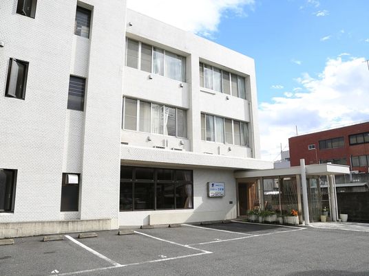 白い外観と駐車場  