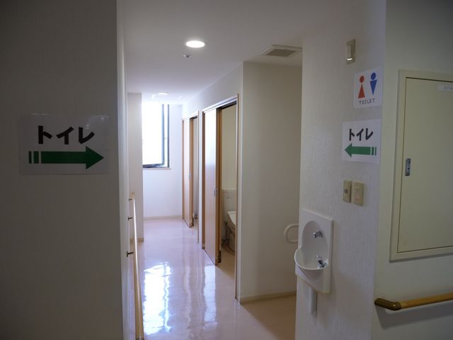 清潔な廊下の様子 トイレ 光が差し込む廊下には、明確な表示があり、安心してお過ごしいただける環境です。