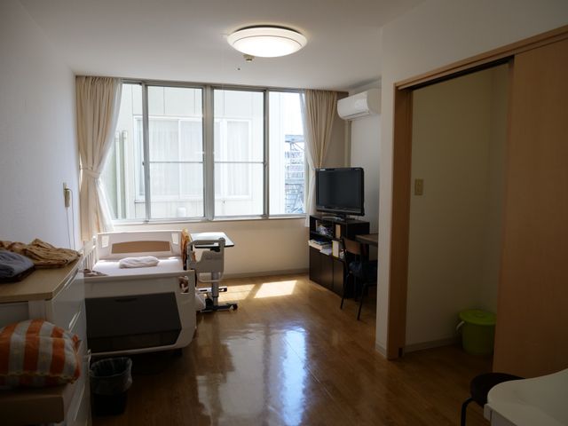 居室の明るい空間 居室 窓からの自然光が入り、明るく温かみのある居室です。日常生活に寄り添う家具が整然と配置され、落ち着いた時間を過ごせる空間となっています。