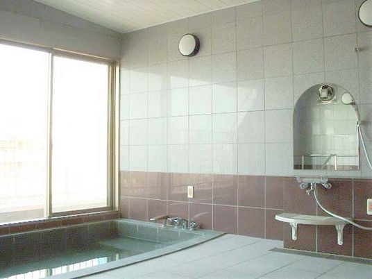 大きめの浴槽が置いてある施設の展望浴室。眺めがよさそうな窓がある様子
