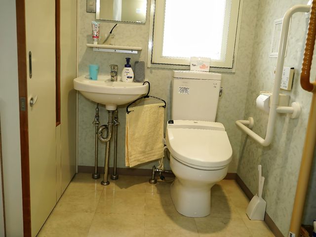 バリアフリーな洗面所 トイレ 手すり付きで安全性を考慮した清潔なトイレ空間です。日々の快適な生活サポートに努めています。