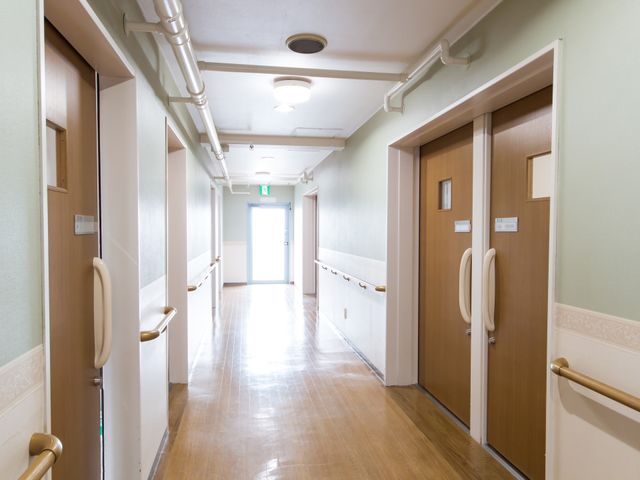 清潔な廊下 通路 ゆとりのある廊下は、バリアフリー設計で、どなた様も快適にお過ごしいただけます。木目調のドアが落ち着いた雰囲気を演出しています。