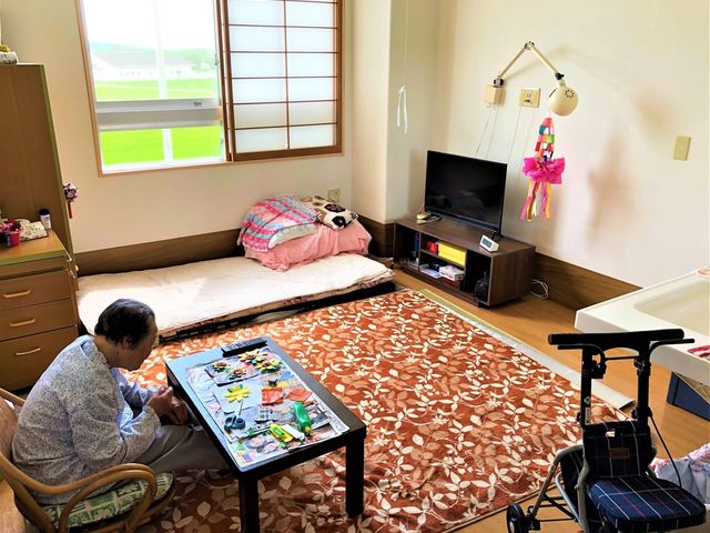 くつろぎの居室 居室 広々とした居室で、窓から自然光が入り、リラックスできる空間です。入居者の方が穏やかに過ごしています。