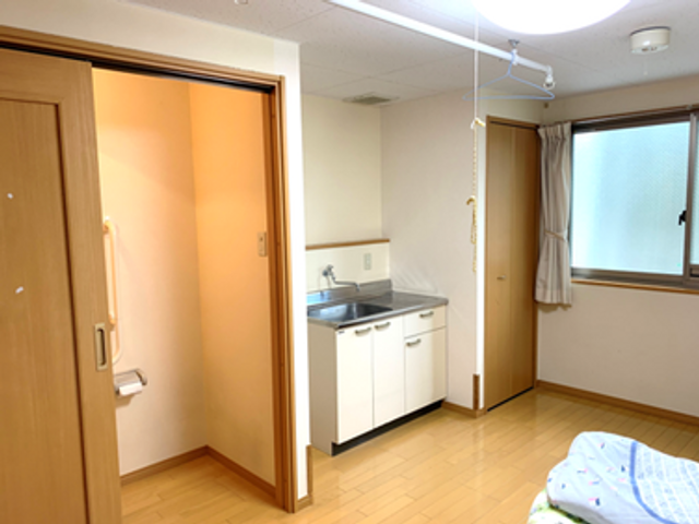 ゆとりの居室 居室 明るい色合いの居室は、家庭的な雰囲気で落ち着いた時間を過ごせそうです。必要な設備も整っており、安心して生活できます。