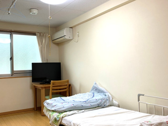 居室の一覧 居室 シンプルな居室には、窓から自然光が差し込み快適な環境が整っています。ベッド周りには必要なものが配置され、落ち着いて過ごせそうです。