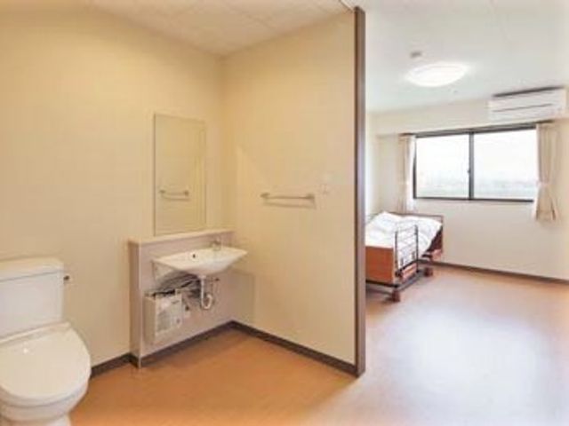 清潔感ある居室 居室 バリアフリー設計の居室は、明るく落ち着いた雰囲気で、利用者様に安心して快適な生活を提供しています。窓から自然光が差し込み、気持ちの良い空間となっております。