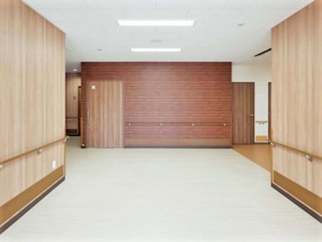 広々とした明るい廊下 エントランス 木目調の壁が落ち着いた雰囲気を醸し出し、ゆったりとした空間で快適な移動やコミュニケーションが可能です。