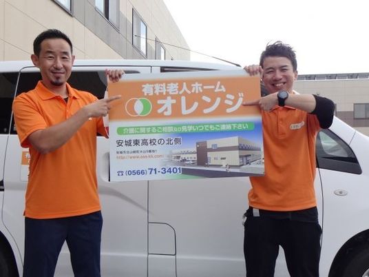送迎車前のスタッフ2人  