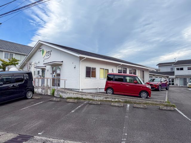 白い建物の外観 外観 車椅子利用者も快適に出入りできる設計です。周辺には駐車スペースも十分にあります。