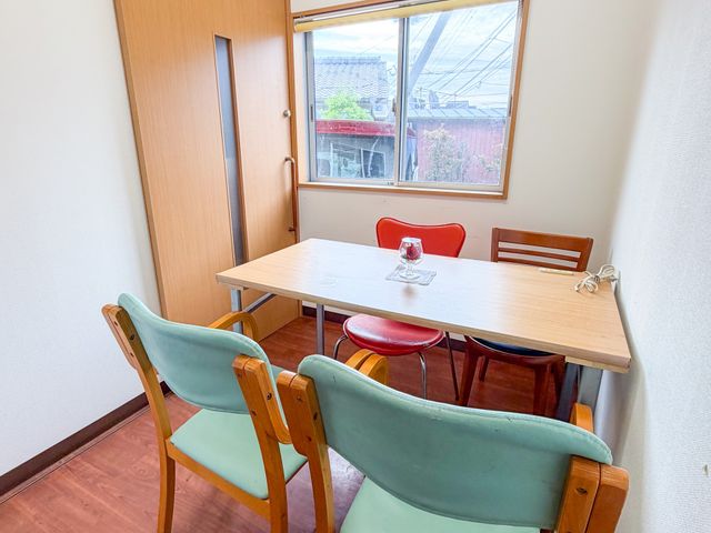 自然光の窓際の部屋 内観 自然光が差し込む落ち着いた空間で、会話や休憩に最適です。椅子とテーブルが配置されています。