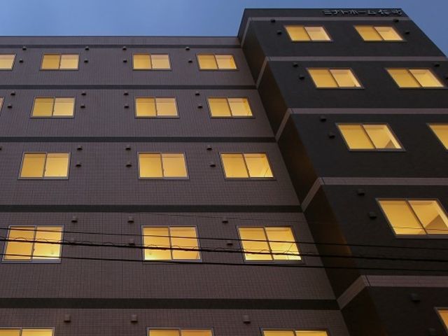 夕暮れ時の建物外観 外観 窓から漏れる光が温もりを感じさせる建物です。夕暮れ時には、穏やかな雰囲気をお楽しみいただけます。