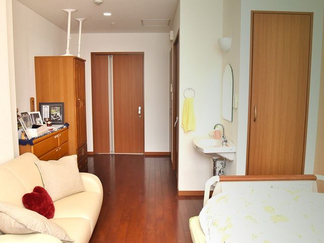 居室の洋室風景 居室 木目調の暖かな雰囲気の居室です。シンプルで使いやすい洗面台が備わり、快適な個人空間をお過ごしいただけます。
