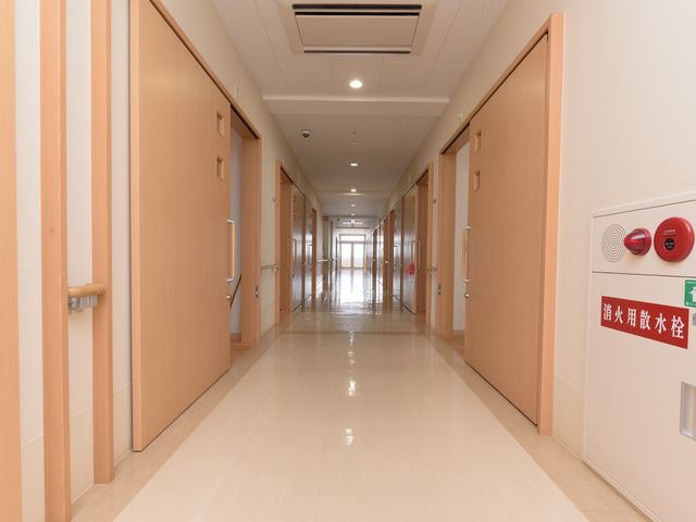 明るい廊下の風景 廊下 ゆったりとした廊下は、清潔感があり、のびのびとお仕事できる環境が整っています。安全に留意した構造で、利用者の快適な移動が支援されます。