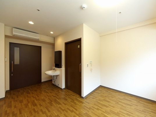 施設の写真 お部屋には洗面所とトイレ、エアコンが付き、出入り口は大きな引き戸となっている。