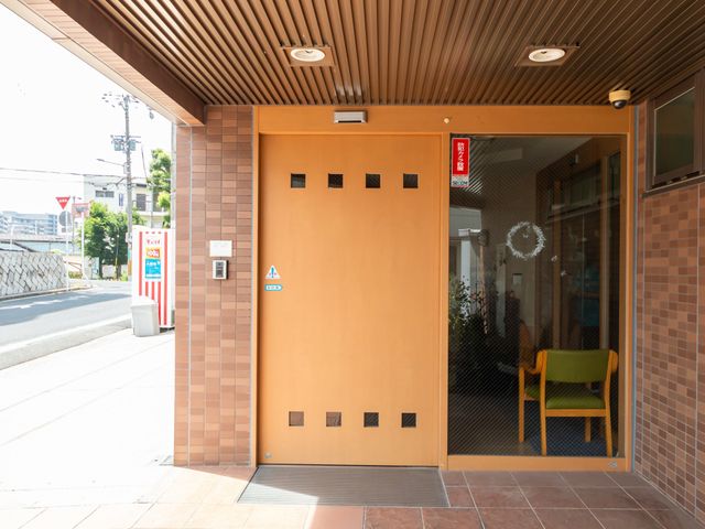 施設のエントランス エントランス 木目調のドアとガラスが調和した清潔感のある入口。リラックスした時間が流れています。