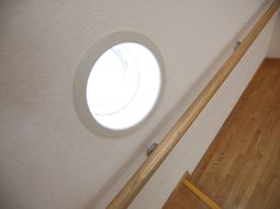 円型の窓と木製の手すり