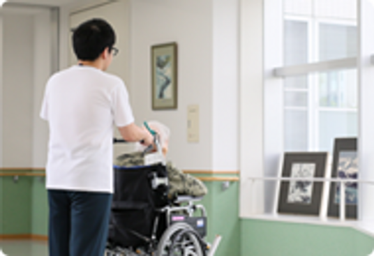 車椅子の利用者と職員の廊下
