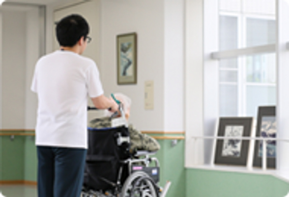 車椅子の利用者と職員の廊下