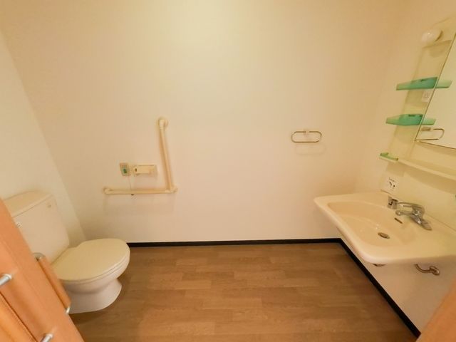 手すり付きの洗面所 トイレ 安心してご使用いただける、手すりが設置された清潔なトイレ空間です。ゆったりとした配置で日々の快適さを考えたデザインとなっています。