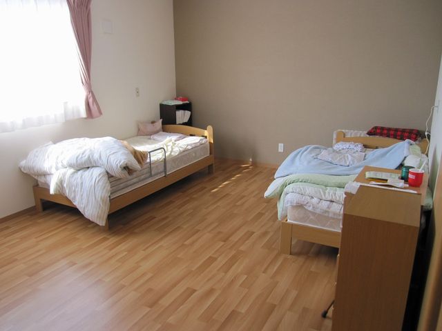 二つのベッドがある居室 居室 やさしい自然光が差し込む広々とした空間で、快適におくつろぎいただけます。