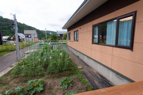 茶色い壁の建物と畑